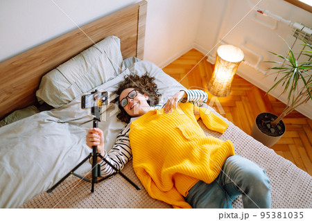 Beautiful fashion blogger holding yellow sweater dreamily recording new fashion video for vlog. Beautiful fashion blogger holding yellow sweater dreamily recording new fashion video for vlog. 95381035