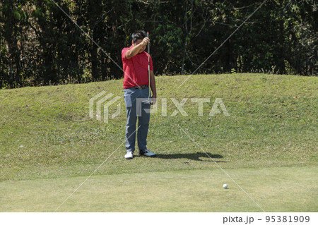 Golfer are playing game golf and hitting go on green grass mountain background. Asia male player game shot in summer. Golfer are playing game golf and hitting go on green grass mountain background. Asia male player game shot in summer. 95381909