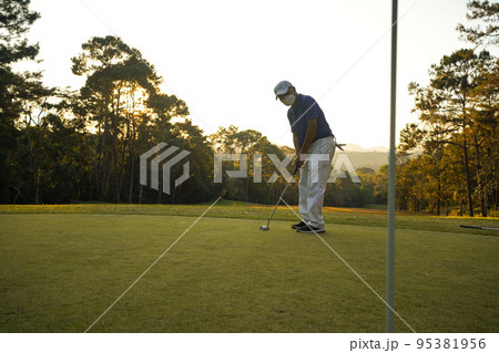 Blurred golfer playing golf in the evening golf course, on sun set evening time. 95381956