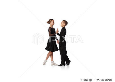 Two kids, school age girl and boy in black stage costumes dancing ballroom dance isolated on white background. Art, sport dance, music, studying 95383696
