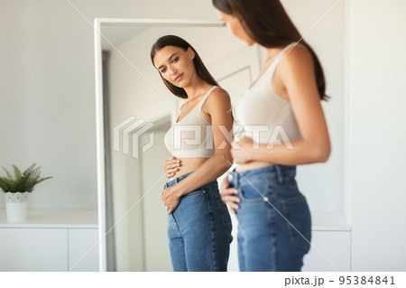 Woman Touching Belly Enjoying First Months Of Pregnancy At Home 95384841