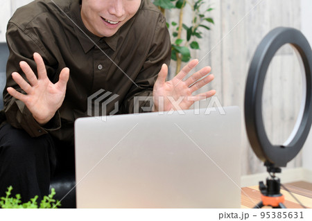 ノートパソコンで動画配信をする若い男性 ノートパソコンで動画配信をする若い男性 95385631