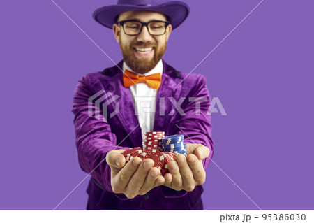 Close up of poker chips in hands of joyful and satisfied man isolated on purple background. 95386030