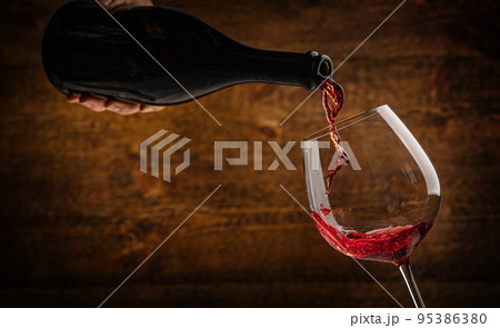 Pouring red wine 95386380