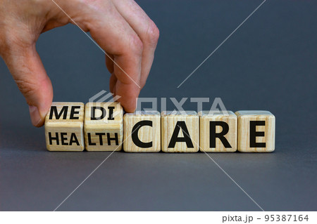 Medicare or healthcare symbol. Doctor turns cubes, changes the word 'healthcare' to 'medicare'. Beautiful grey background. Copy space. Medical, medicare or healthcare concept. Medicare or healthcare symbol. Doctor turns cubes, changes the word 'healthcare' to 'medicare'. Beautiful grey background. Copy space. Medical, medicare or healthcare concept. 95387164