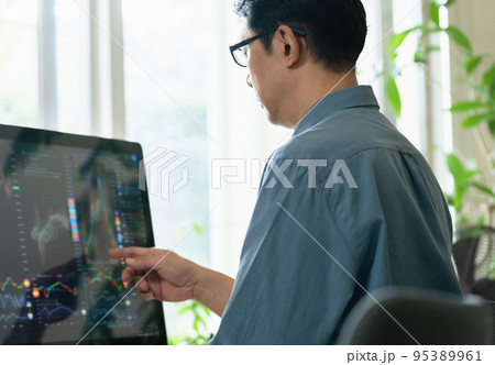 自宅で株のトレードをするミドル男性 95389961
