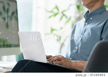 自宅で株のトレードをするミドル男性 95389963