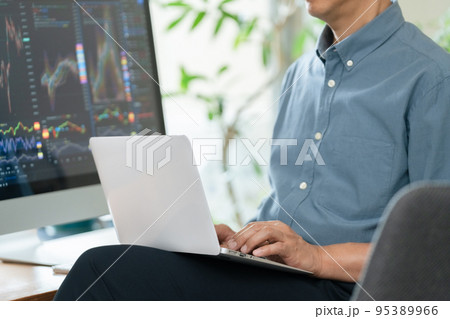 自宅で株のトレードをするミドル男性 95389966