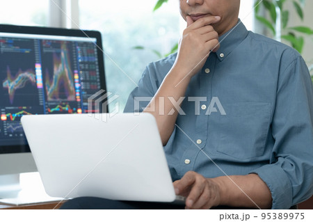 自宅で株のトレードをするミドル男性 95389975