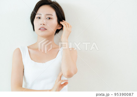 壁の前でポージングする女性 95390087