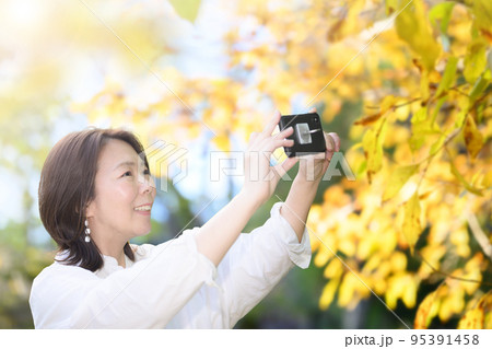 紅葉狩りなどの秋の観光を楽しむ女性　黄色 95391458