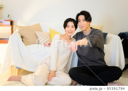 夜に動画やテレビなどを見てくつろぐカップル 95391794