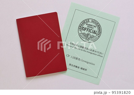 Red passport and immigration document handed at Haneda Airport, Tokyo, Japan. October 19, 2022. Red passport and immigration document handed at Haneda Airport, Tokyo, Japan. October 19, 2022. 95391820