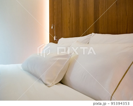 Clean Bedding sheets and pillow on natural wall room background. Clean Bedding sheets and pillow on natural wall room background. 95394353