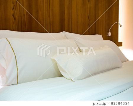 Clean Bedding sheets and pillow on natural wall room background. Clean Bedding sheets and pillow on natural wall room background. 95394354