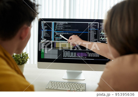 Young developers checking programing code on computer screen 95395636