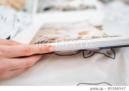 Selective focus and blurry photos. a woman holds a photo book. Selective focus and blurry photos. a woman holds a photo book. 95396547