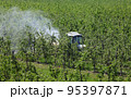 Agriculture, spraying of trees in orchard 95397871