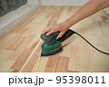 Home renovation, worker sanding wooden stairs or floor 95398011