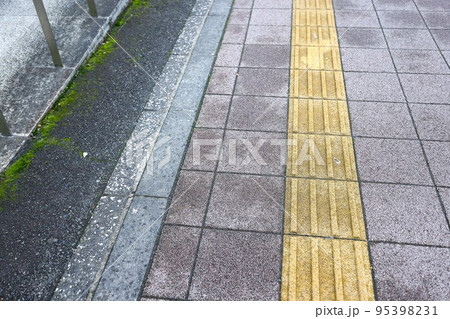 雨上がり、小雨の降る街と点字ブロックと歩道 雨上がり、小雨の降る街と点字ブロックと歩道 95398231