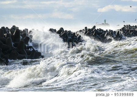 Big waves breaking over harbor breakwall concrete tetrapods Big waves breaking over harbor breakwall concrete tetrapods 95399889