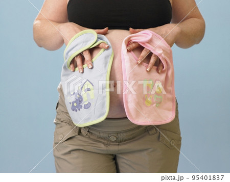 Pregnant woman holding bibs 95401837