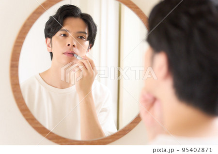 鏡の前でリップを塗る若い男性 メンズビューティー イメージ 鏡の前でリップを塗る若い男性 メンズビューティー イメージ 95402871