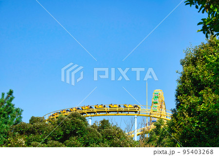 ジェットコースターの黄色いレールが、青空に映えている風景 95403268