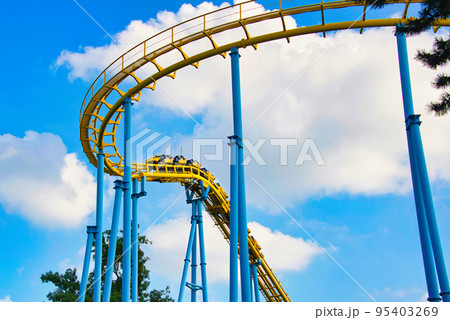 ジェットコースターの黄色いレールが、青空に映えている風景 95403269