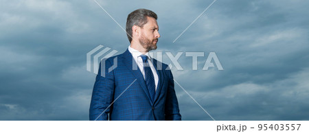 Portrait of grizzled man in suit. Serious man looking aside. Professional man sky background 95403557