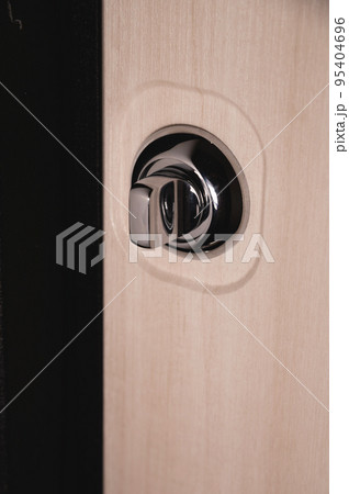 Close up of stylish silver chrome door handle on modern interior door. Stylish light brown door with frosted glass inserts. Concept of catalog of door handles for furniture store Close up of stylish silver chrome door handle on modern interior door. Stylish light brown door with frosted glass inserts. Concept of catalog of door handles for furniture store 95404696