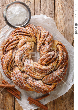 Kringle Delicious Brioche with sugar and cinnamon closeup on the paper. Vertical top view 95405022