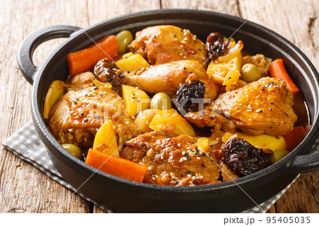 Gallo en chicha stew with chicken, prunes, vegetables, and spices cooked to have a wonderful flavor and aroma closeup on the pan. Horizontal 95405035