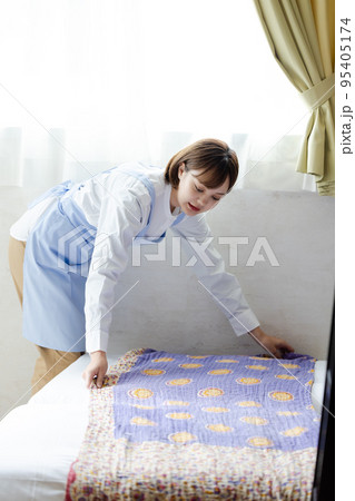 ベッドメイクをする可愛い女性 95405174