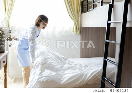 ベッドメイクをする可愛い女性 ベッドメイクをする可愛い女性 95405182