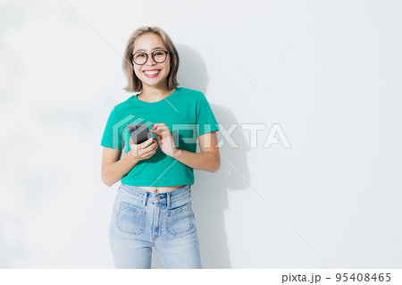 スマホ グリーンのTシャツの女性 スマホ グリーンのTシャツの女性 95408465