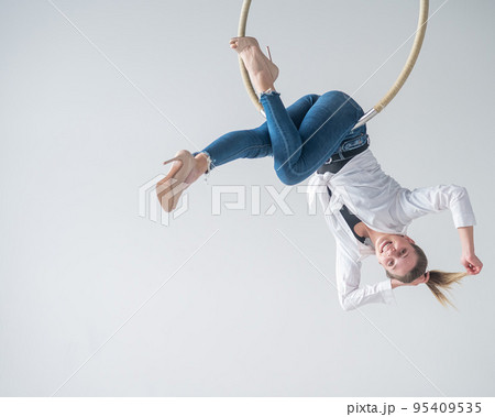 Caucasian woman in casual clothes on an aerial hoop.  95409535