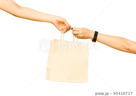 Hand holding and giving paper bag to other hand isolated in white background. Hand holding and giving paper bag to other hand isolated in white background. 95410717