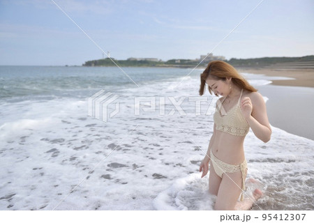 海岸にてビキニの水着を着た若い女性 95412307