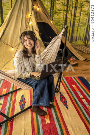 ワーケーション　キャンプ場で仕事をする若い女性　ヘッドセット 95412873