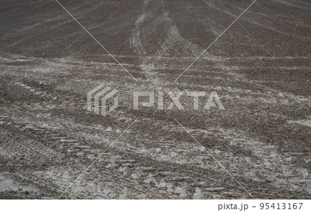 Agriculture. Tractor cultivated land. A field with traces of wheeled vehicles in early spring for sowing cereals. 95413167