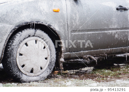 Gray passenger car covered with ice. Frozen Ice Rain. . Ice. Close-up view. 95413291