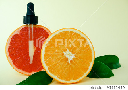 Dropper bottle filled with citrus oil. Juicy ripe citrus fruit slices. lemon. Orange. Grapefruit. Grape. Skin care. Organic, bio cosmetics healthy concept 95413450