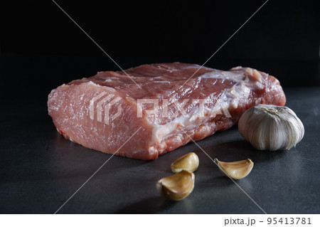 Raw meat. Juicy, appetizing cue ball with a piece and cut with spices on a gray background. Raw meat. Juicy, appetizing cue ball with a piece and cut with spices on a gray background. 95413781