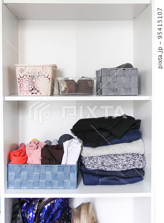 Different clothes in home wardrobe. Small space organization. Vertical storage. Different clothes in home wardrobe. Small space organization. Vertical storage. 95415107