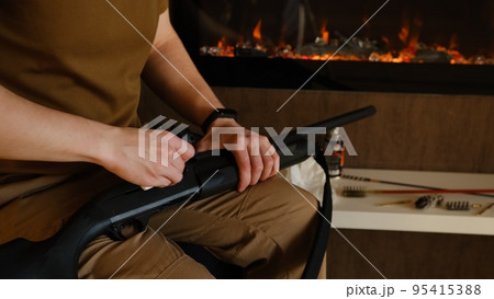 Gunsmith cleaning gun rifle assemble dismantle maintenance. Opening of the spring hunting season. A man cleans rifle aim, maintenance before hunting. Close up on hands with fireplace on background 95415388