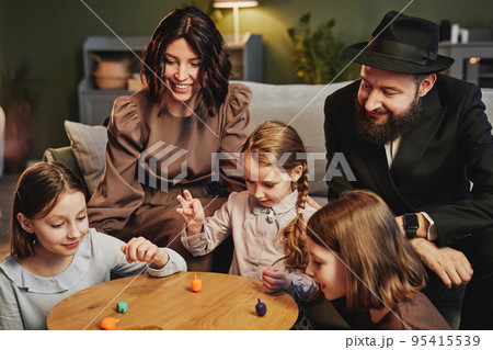 Cozy Jewish Family Playing Dreidel 95415539