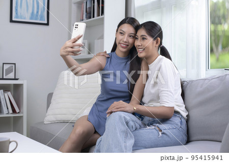 Asian lesbian couple taking selfie in the living room. LGBT couple lifestyle concept. 95415941