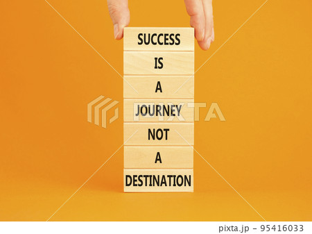 Success is a journey symbol. Concept words Success is a journey not a destination on wooden blocks on a beautiful orange background. Businessman hand. Business and success journey concept. Copy space Success is a journey symbol. Concept words Success is a journey not a destination on wooden blocks on a beautiful orange background. Businessman hand. Business and success journey concept. Copy space 95416033