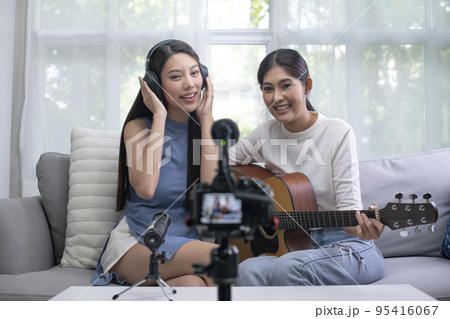 Asian lesbian couple blogger vlogger and online influencer recording musical video content Asian lesbian couple blogger vlogger and online influencer recording musical video content 95416067